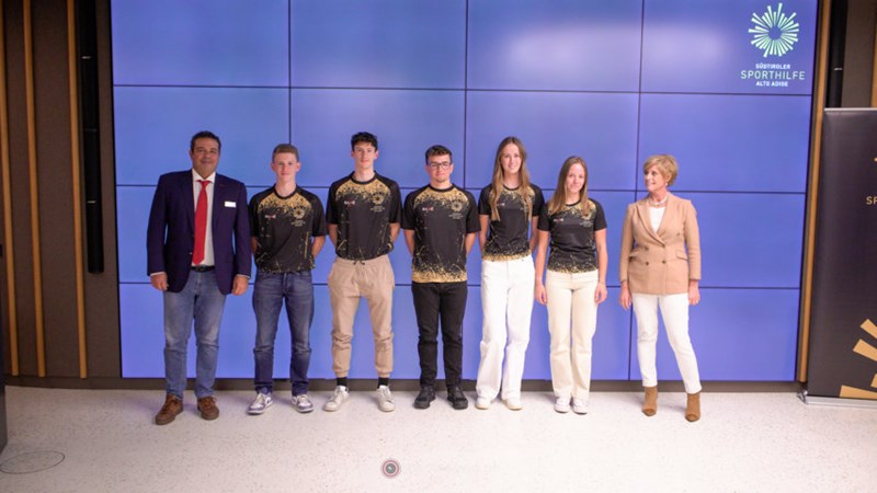 Sporthilfe Präsident Giovanni Podini und Alperia-Vorstandsvorsitzende Flora Kröss mit den anwesenden Sportlerinnen und Sportlern der Disziplin Biathlon.