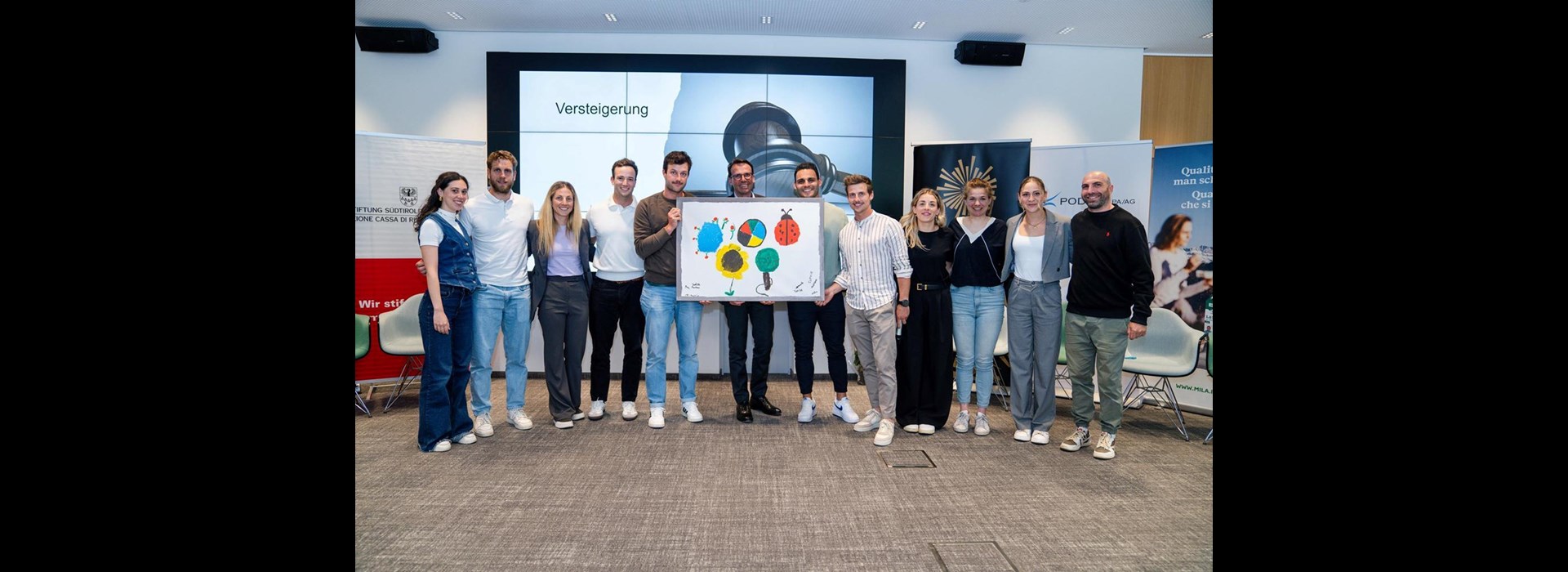 Gli ospiti del KIMM hanno reinterpretato i cinque cerchi olimpici; l’opera è stata messa all’asta a maggio in occasione della conclusione del programma di formazione Great Season. Nella foto: i partecipanti e Christoph Kasslatter di Markas.